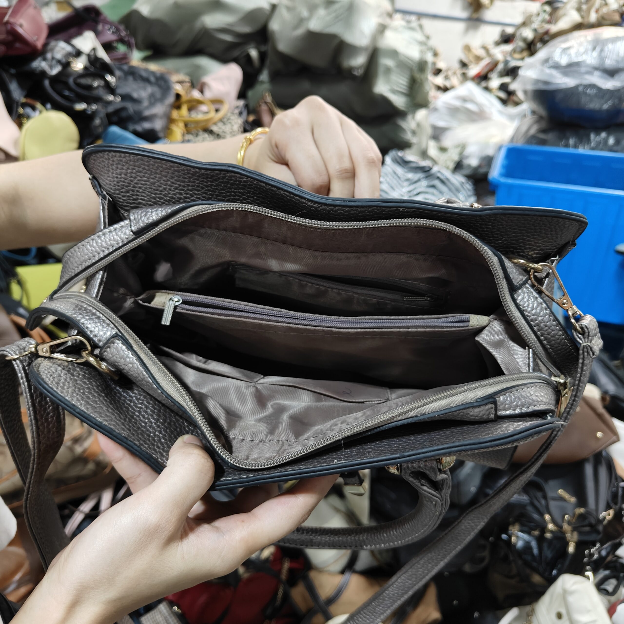 Silver leather crossbody bag with multiple compartments and zippers, suitable for everyday use.