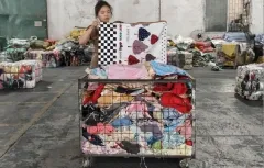 The image shows a large container filled with various types of used clothing bales, including different colors and styles. The container is labeled "RossBoss," indicating it is from a professional B2B factory-direct supplier of used clothing, shoes, and bags based in Guangzhou, China. The bales are likely intended for wholesale distribution to importers across Africa, Southeast Asia, the Middle East, and South America.