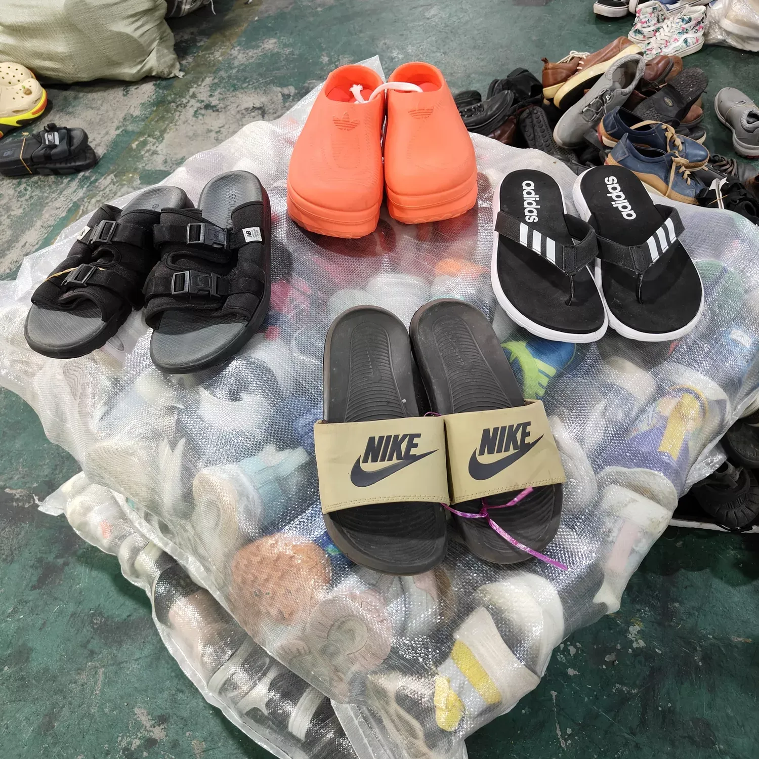 Adidas and Nike branded sandals and slippers available in various colors including black, orange, and khaki, suitable for wholesale export from China to global markets.
