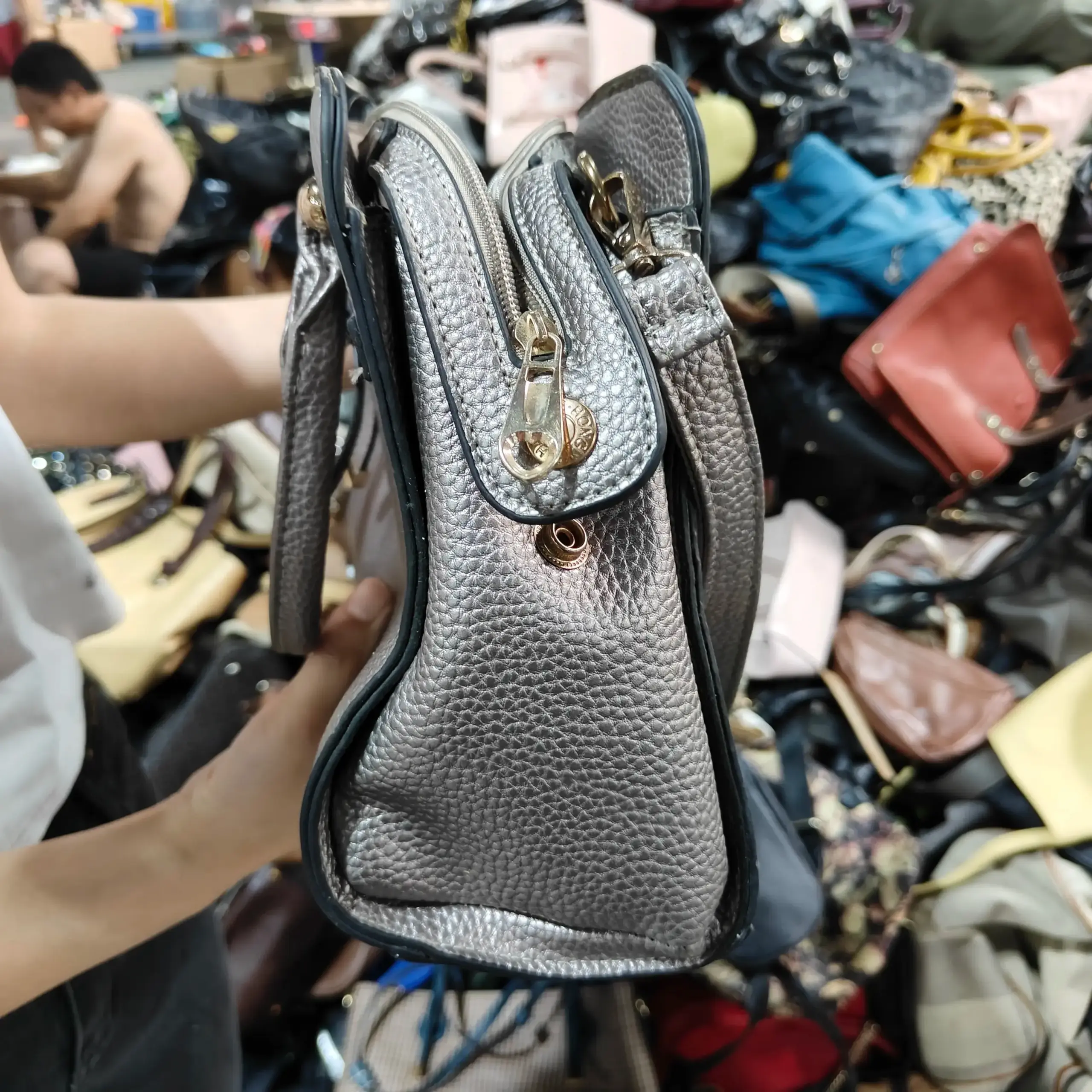 Silver leather ladies' bag with gold-tone hardware and multiple compartments.