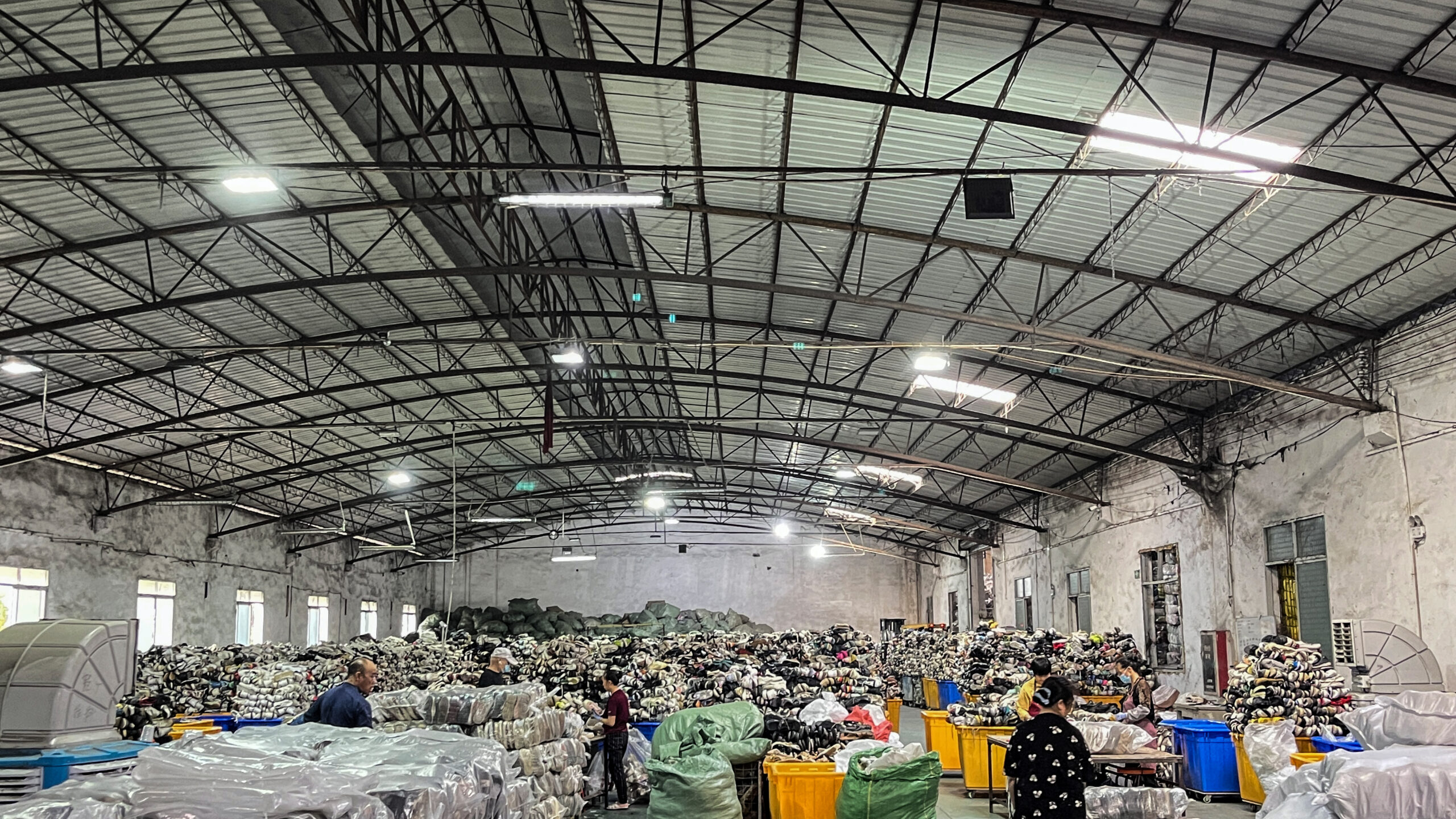 Workers sorting and grading used clothing for a bulk order